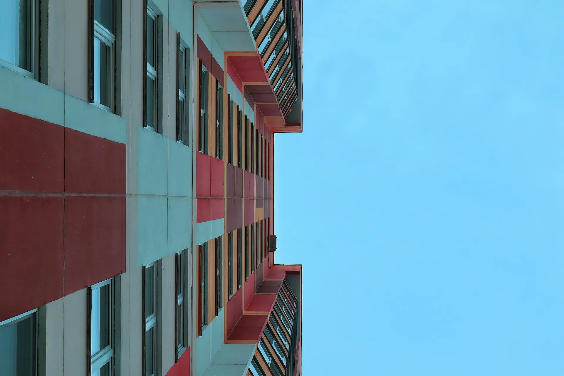 a red and white building with a blue sky in the background